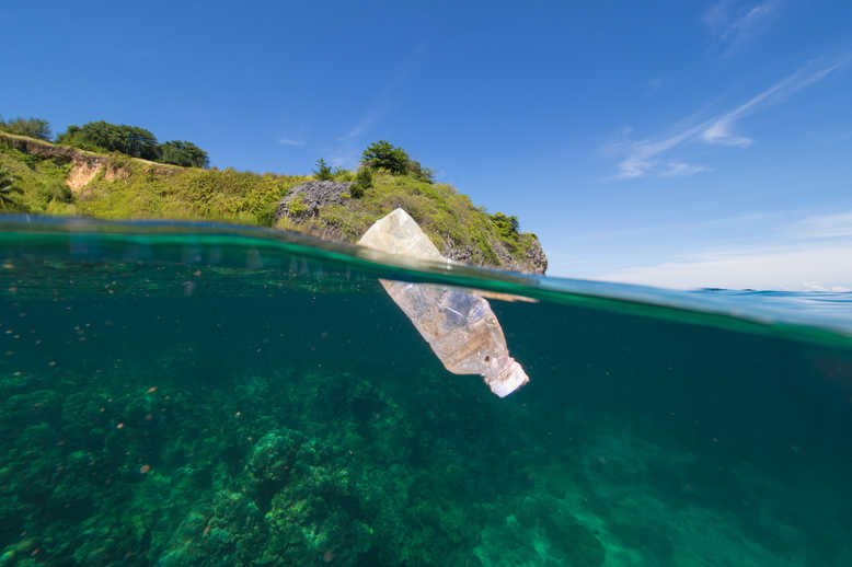 Plastic bottle floating on water surface. [photo by Manufacturing Global]